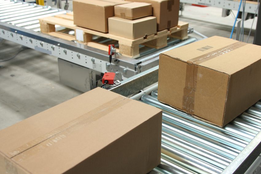 Boxes on conveyor belt in logistics distribution warehouse.