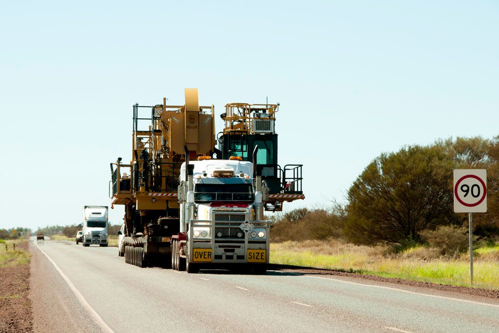semi truck hauling oversize load of heavy construction equipment